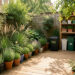 Petit jardin urbain verdoyant avec terrasse en bois, plantes variées, composteur discret et rangement extérieur soigneusement organisé.