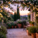 Terrasse de jardin paisible au crépuscule, entourée de jasmin fleuri et de plantes parfumées baignées d’une lumière douce.